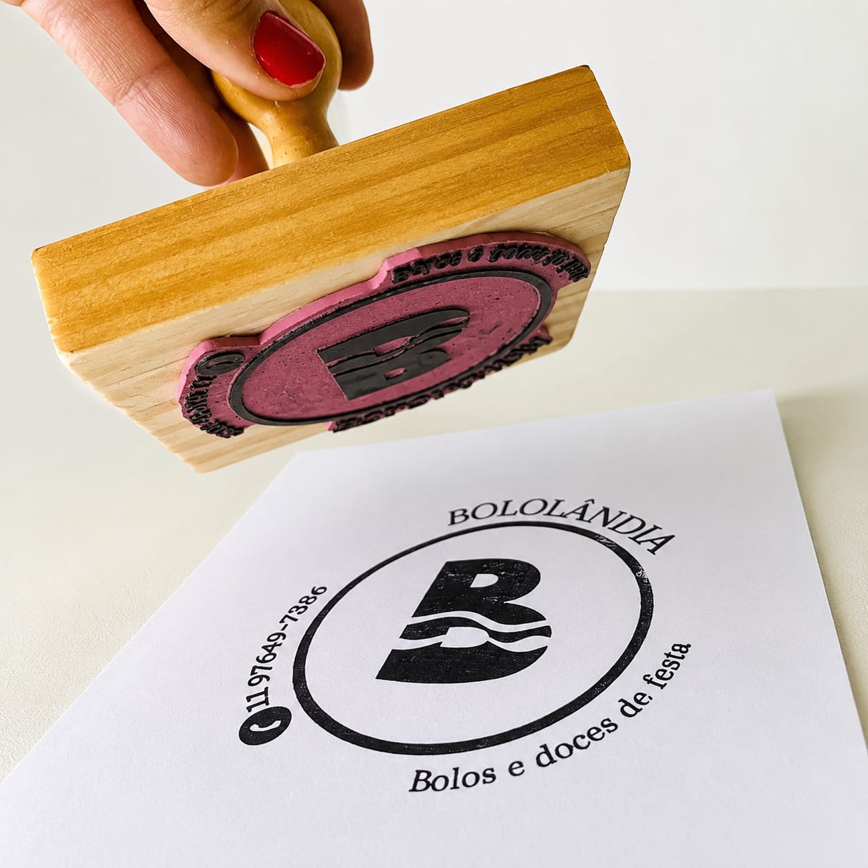 Carimbos de madeira com logomarca carimbando papel branco